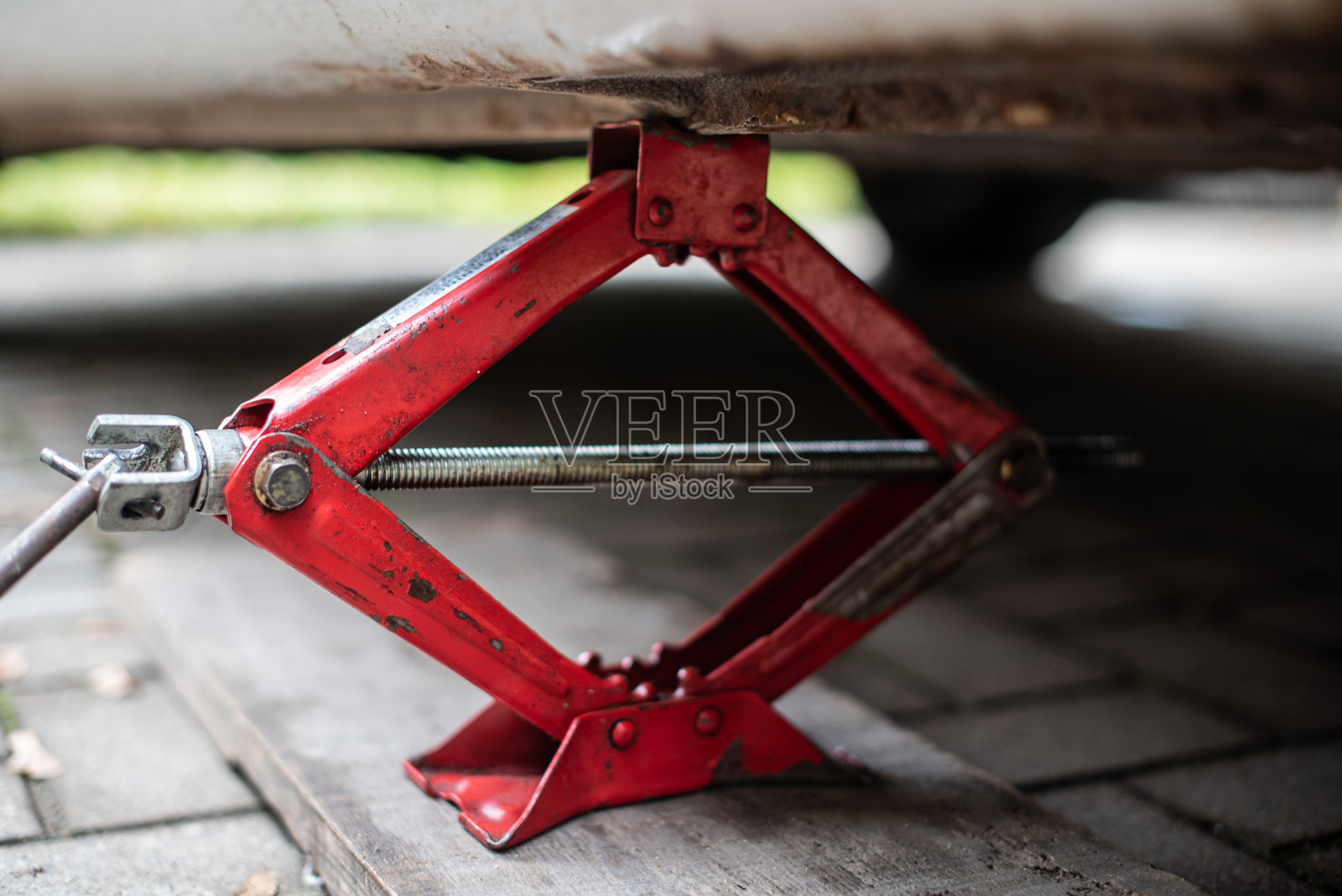 用红色的液压千斤顶将汽车顶起以更换轮胎照片摄影图片