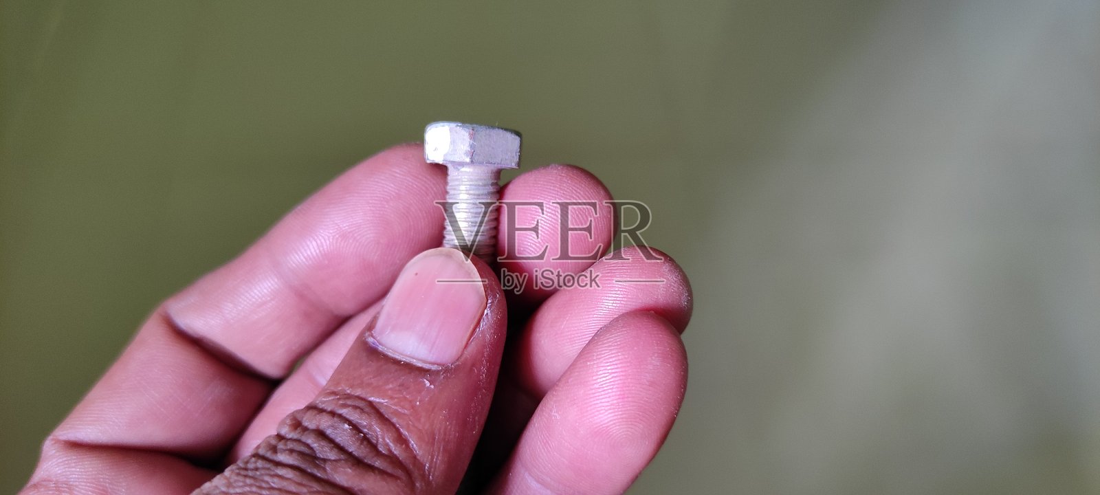 手拿铁螺母和螺栓照片摄影图片