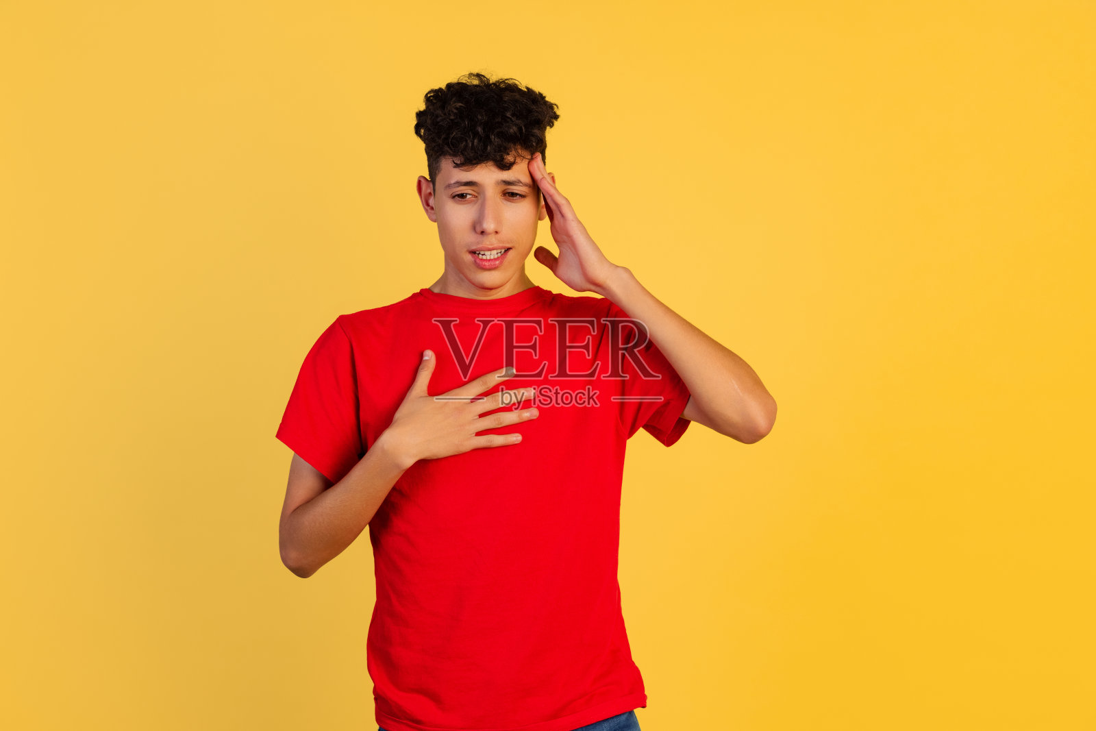 小男孩的裁剪肖像在红色t恤触摸头孤立在黄色背景。艰难的思考过程照片摄影图片