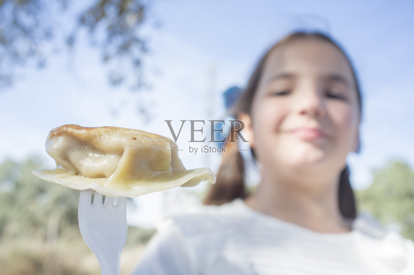 小女孩用叉子吃饺子照片摄影图片