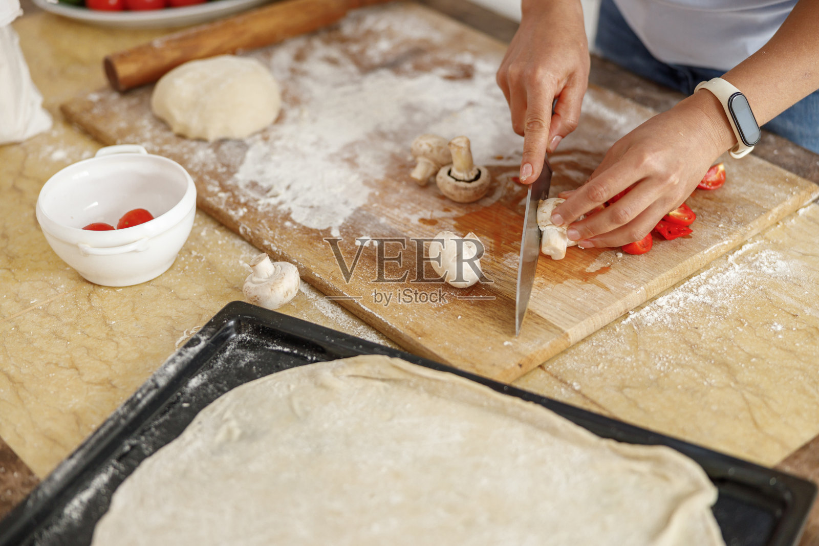 美丽的女人在家里的厨房里做着美味的菜肴照片摄影图片