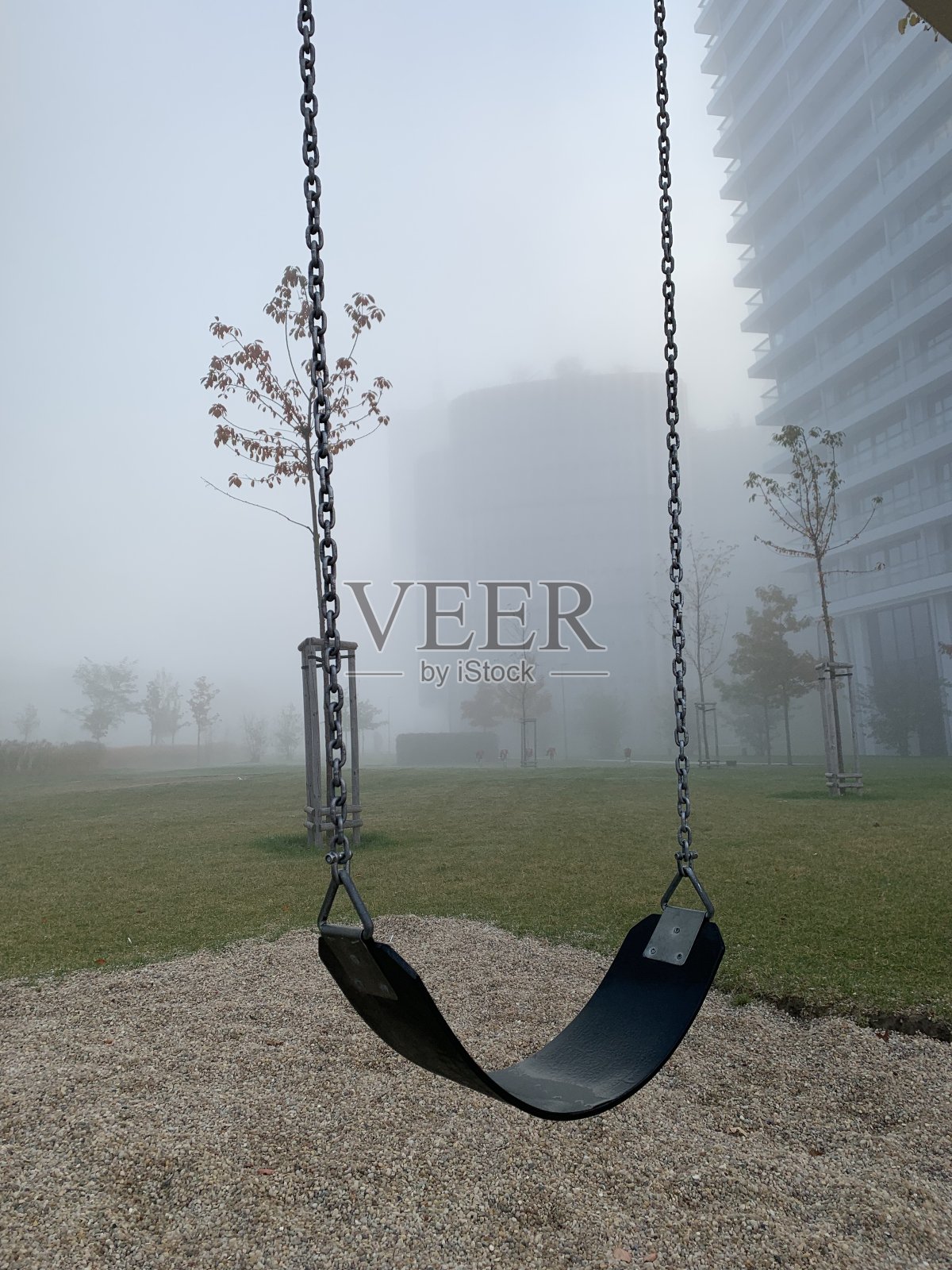 一个雾蒙蒙的早晨,空荡荡的秋千照片摄影图片