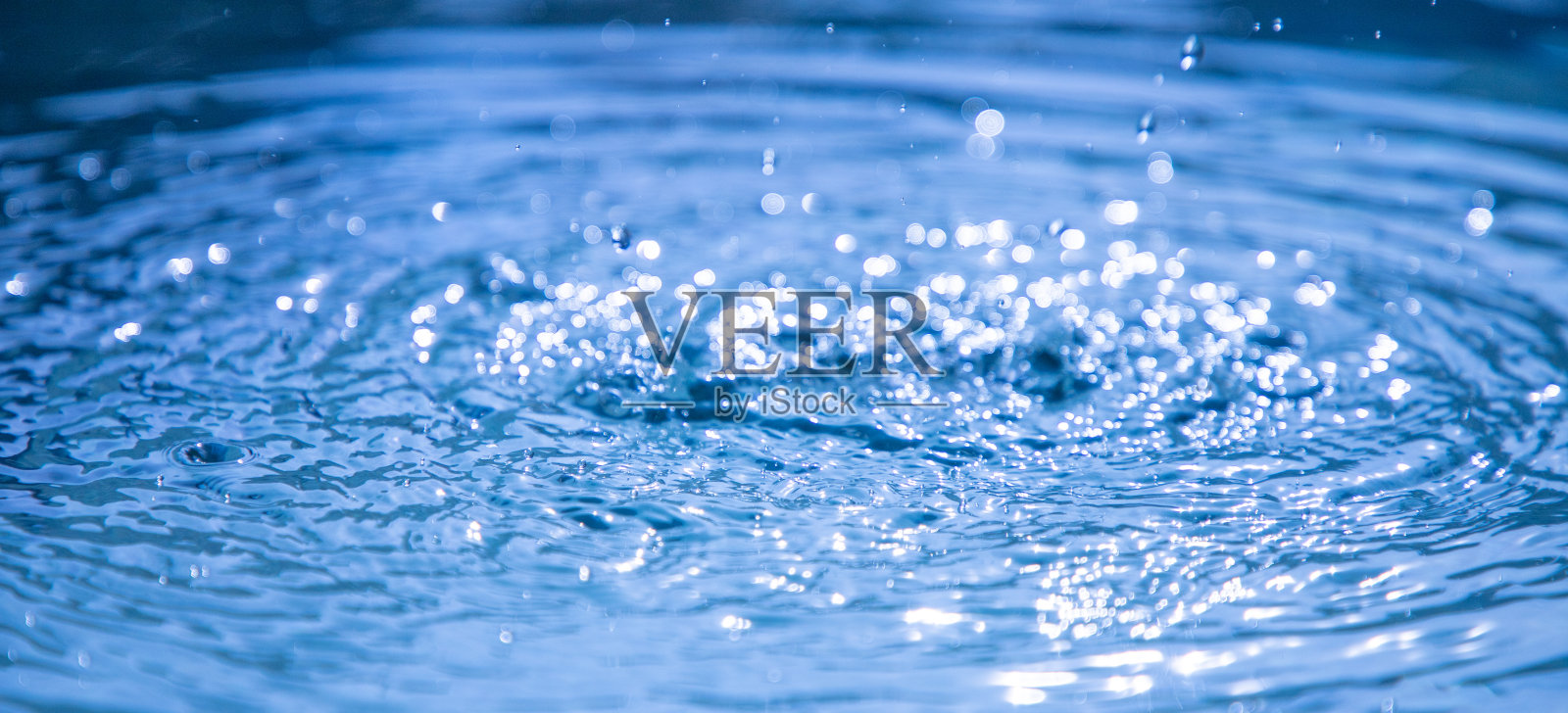 蓝色的水面上有水滴照片摄影图片