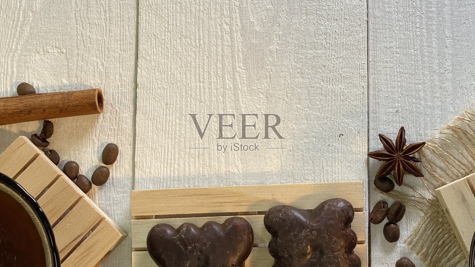 在一张漆成白色的木桌上,放着咖啡杯和姜饼饼干照片摄影图片