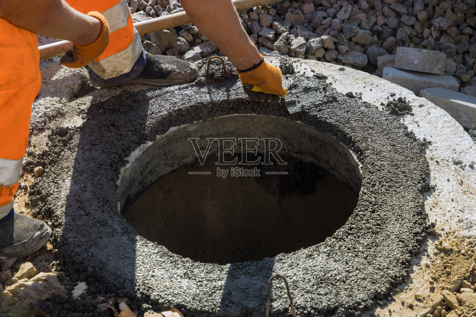 一名工人正在施工新道路,为安装下水道口做准备工作照片摄影图片