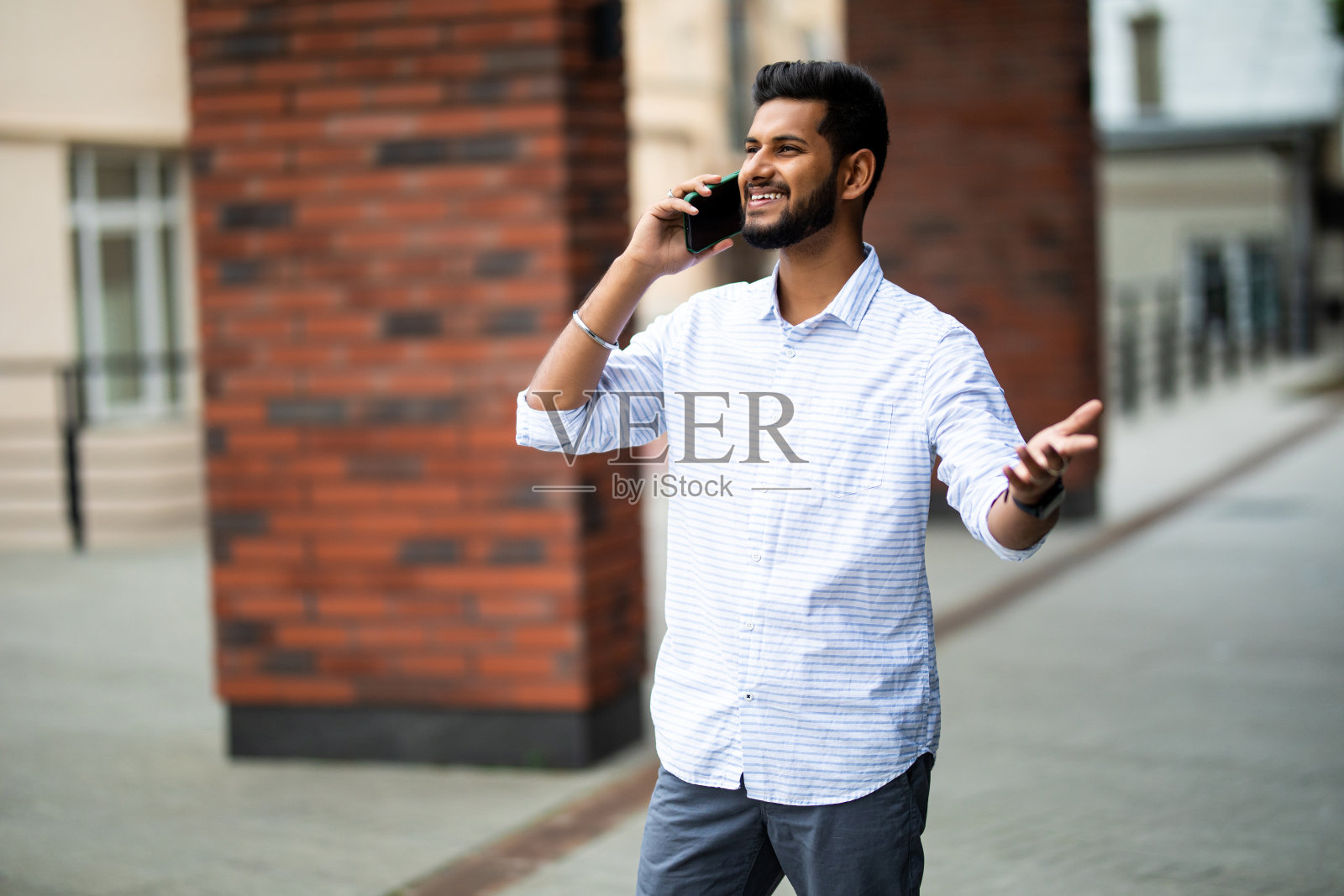 年轻的印度商人在户外打电话照片摄影图片