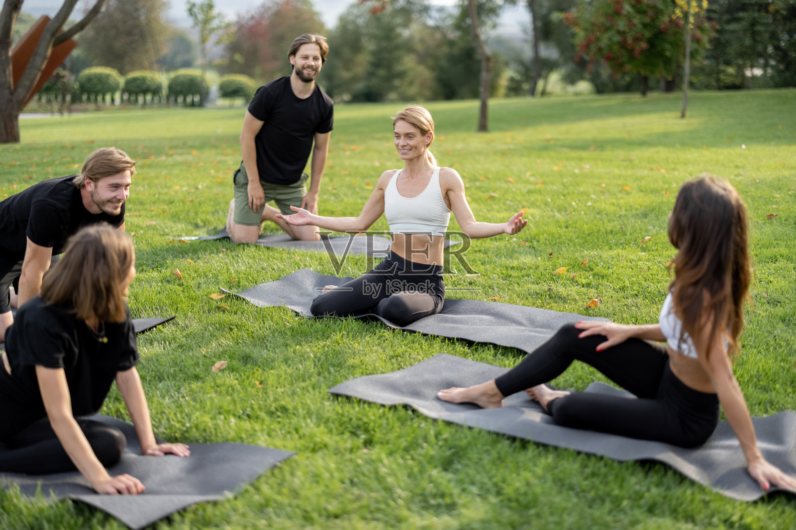 人们在草地上的健身垫上休息照片摄影图片