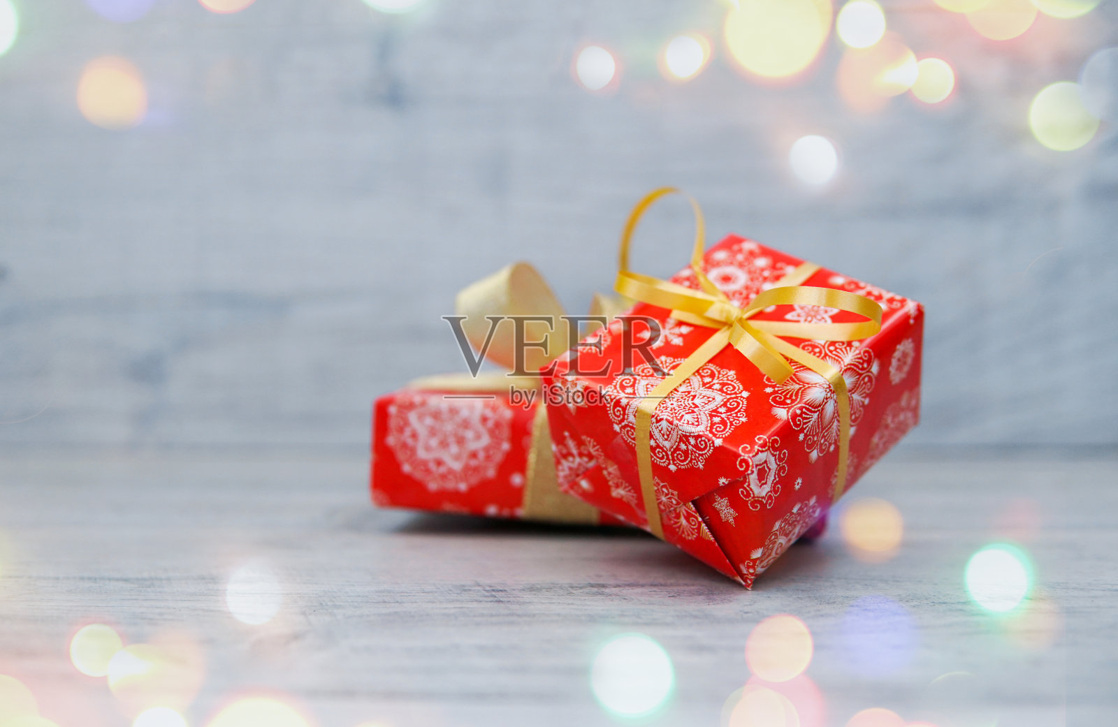 红色的新年礼物,金色的丝带和灰色背景的盒子照片摄影图片
