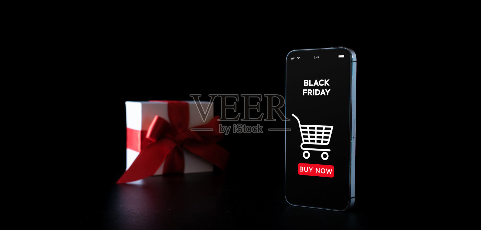 购物礼物。手机上的互联网在线应用程序,白色礼品盒与红丝带孤立在黑色背景在黑色星期五的概念。季节销售的概念。照片摄影图片