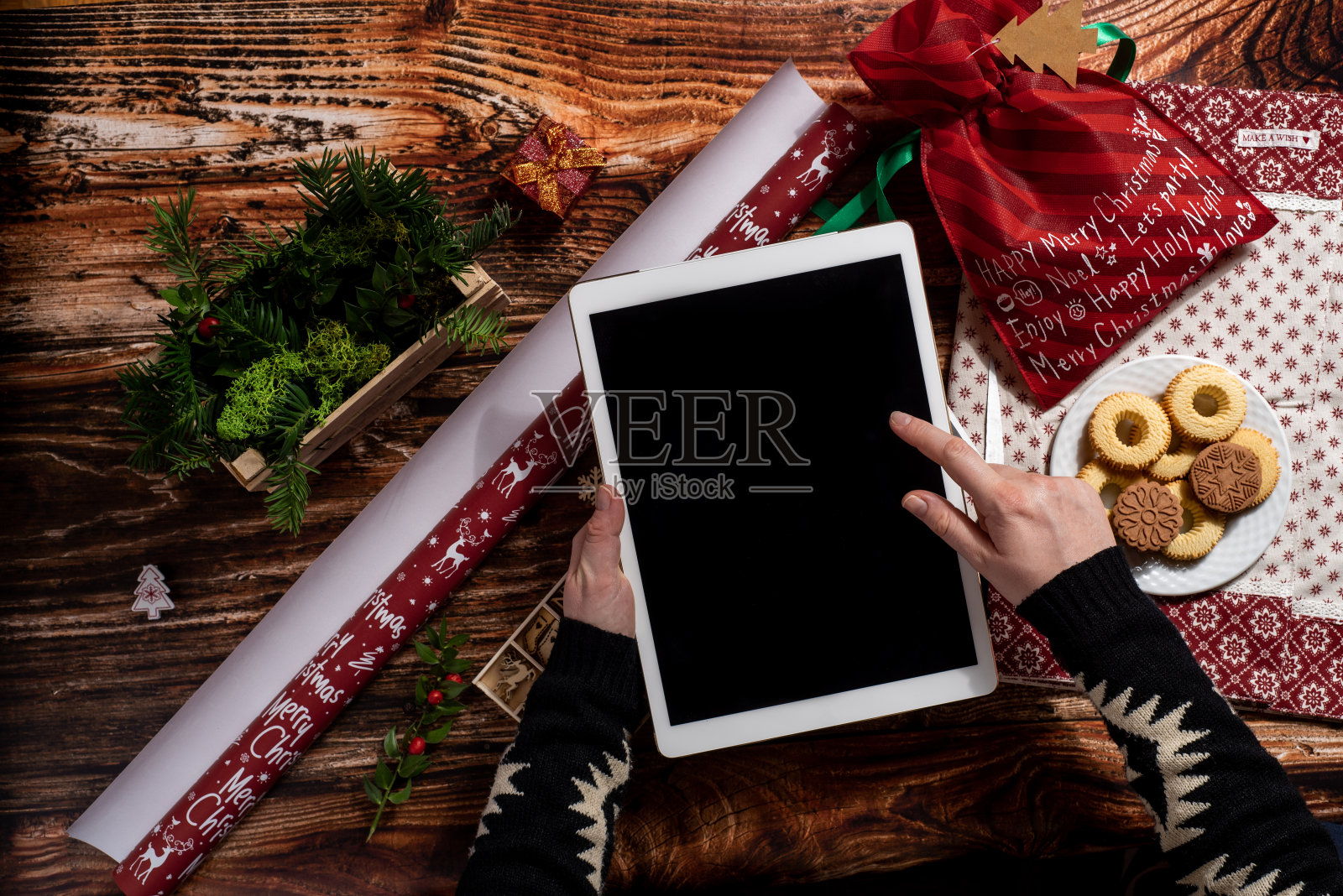 俯视图的妇女的手握数字平板电脑,而包装圣诞礼物照片摄影图片