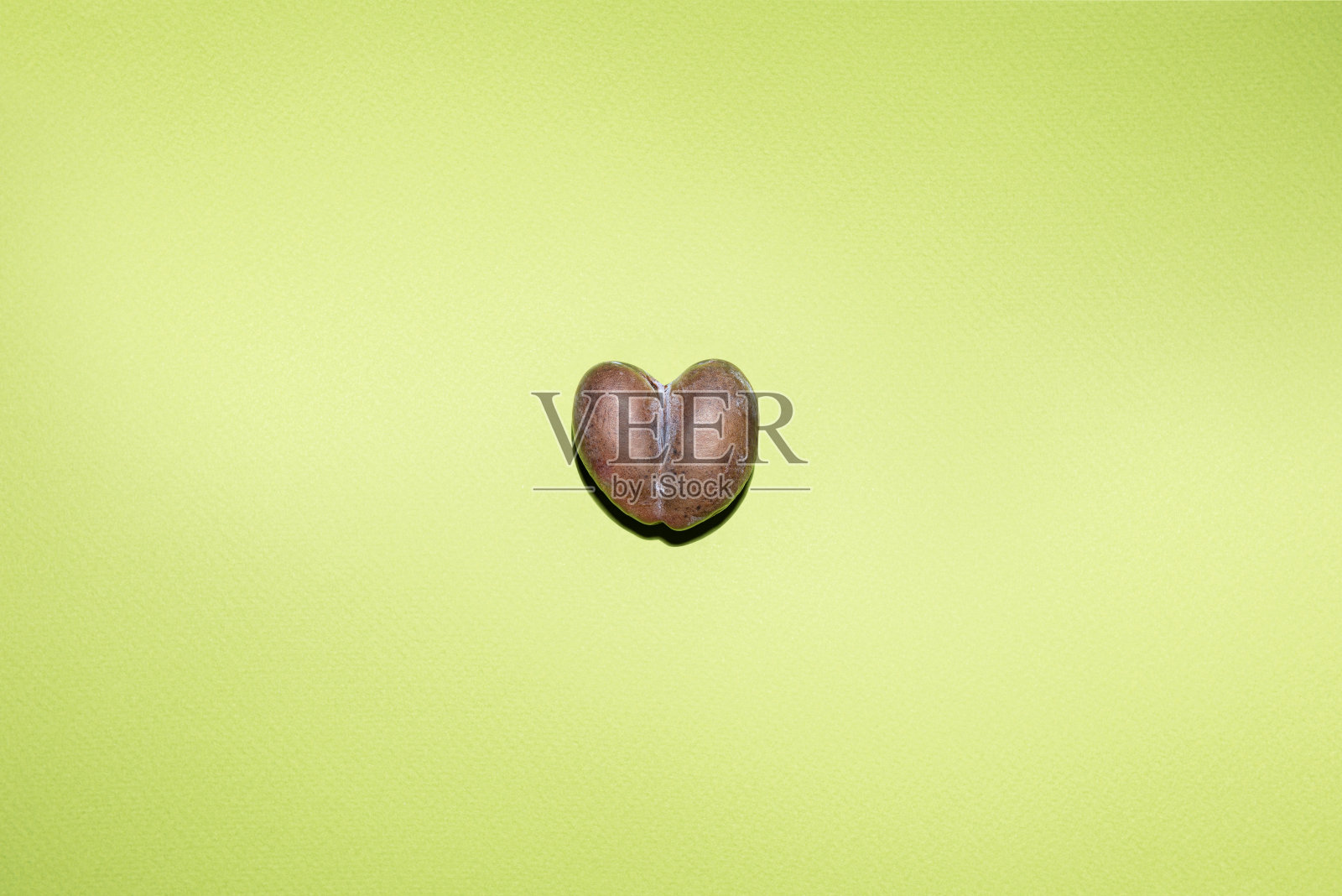 成熟的心形李子在绿纸背景上。照片摄影图片