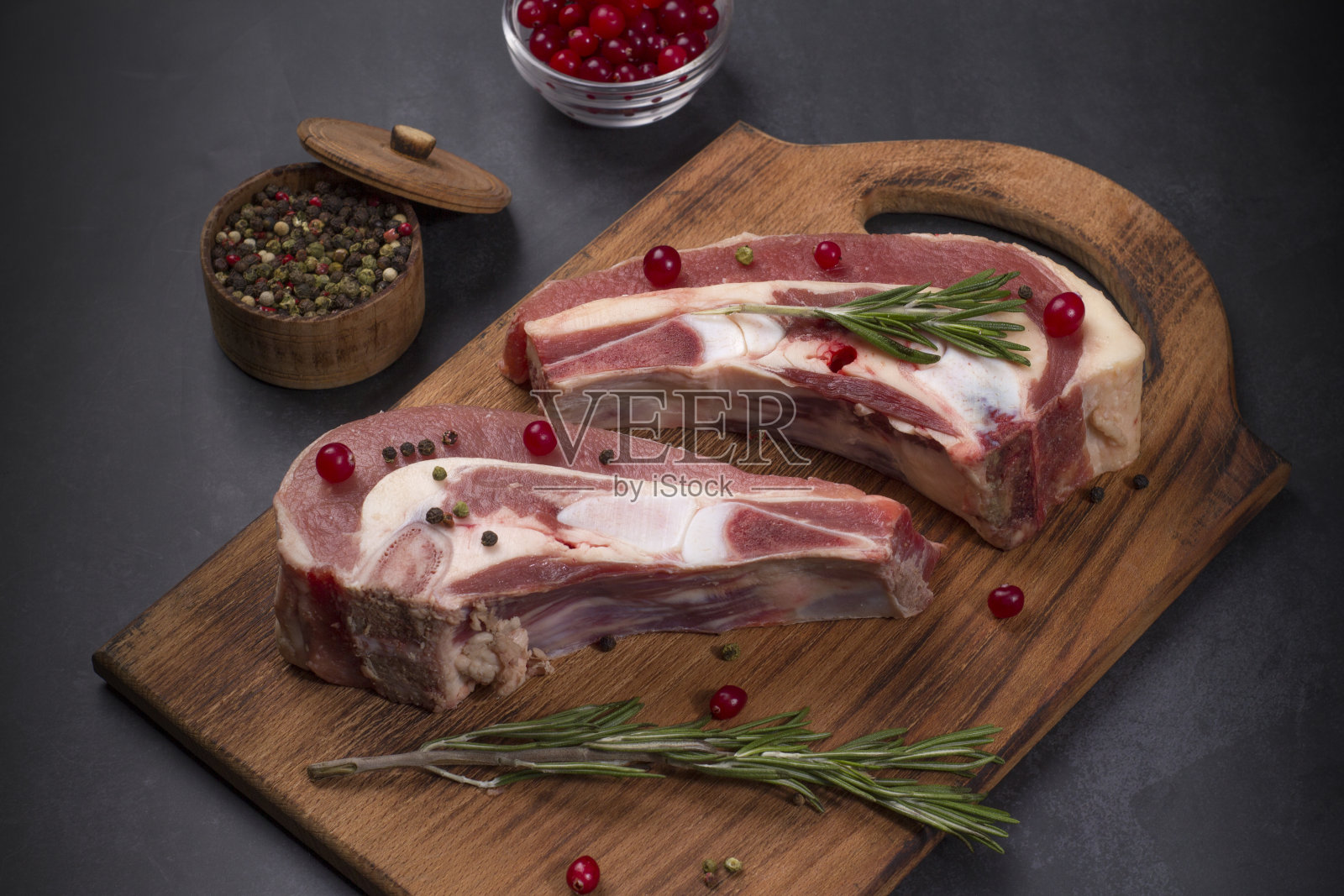 几块新鲜的生牛胸肉在骨头上,在黑色的背景上照片摄影图片