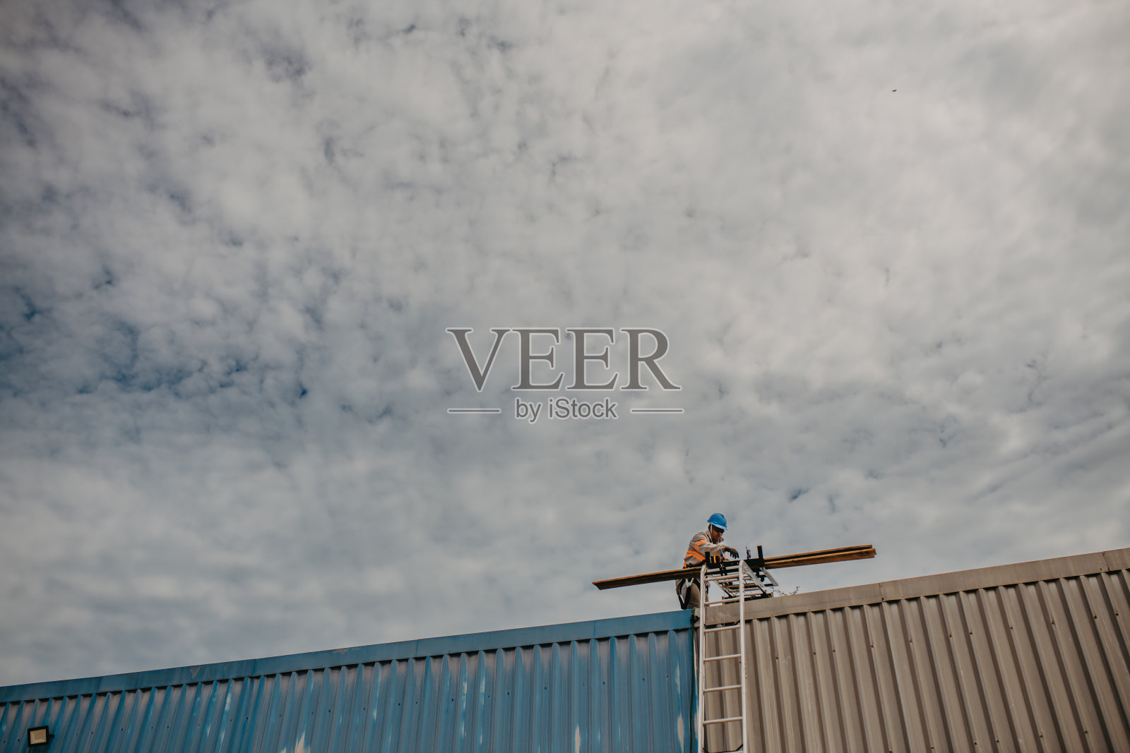 一名男子在屋顶安装太阳能电池板照片摄影图片