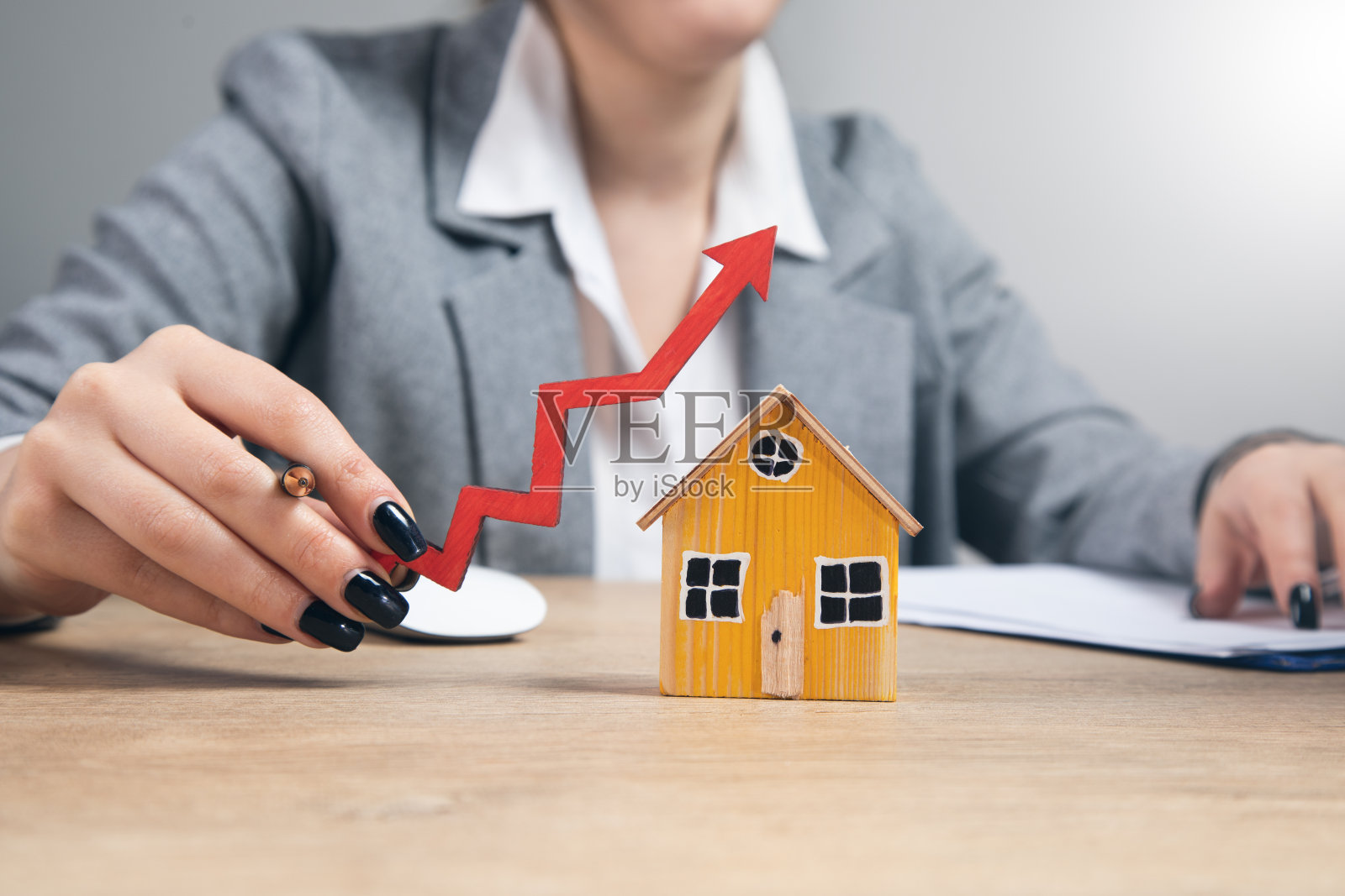 女人拿着带箭的房子模型照片摄影图片