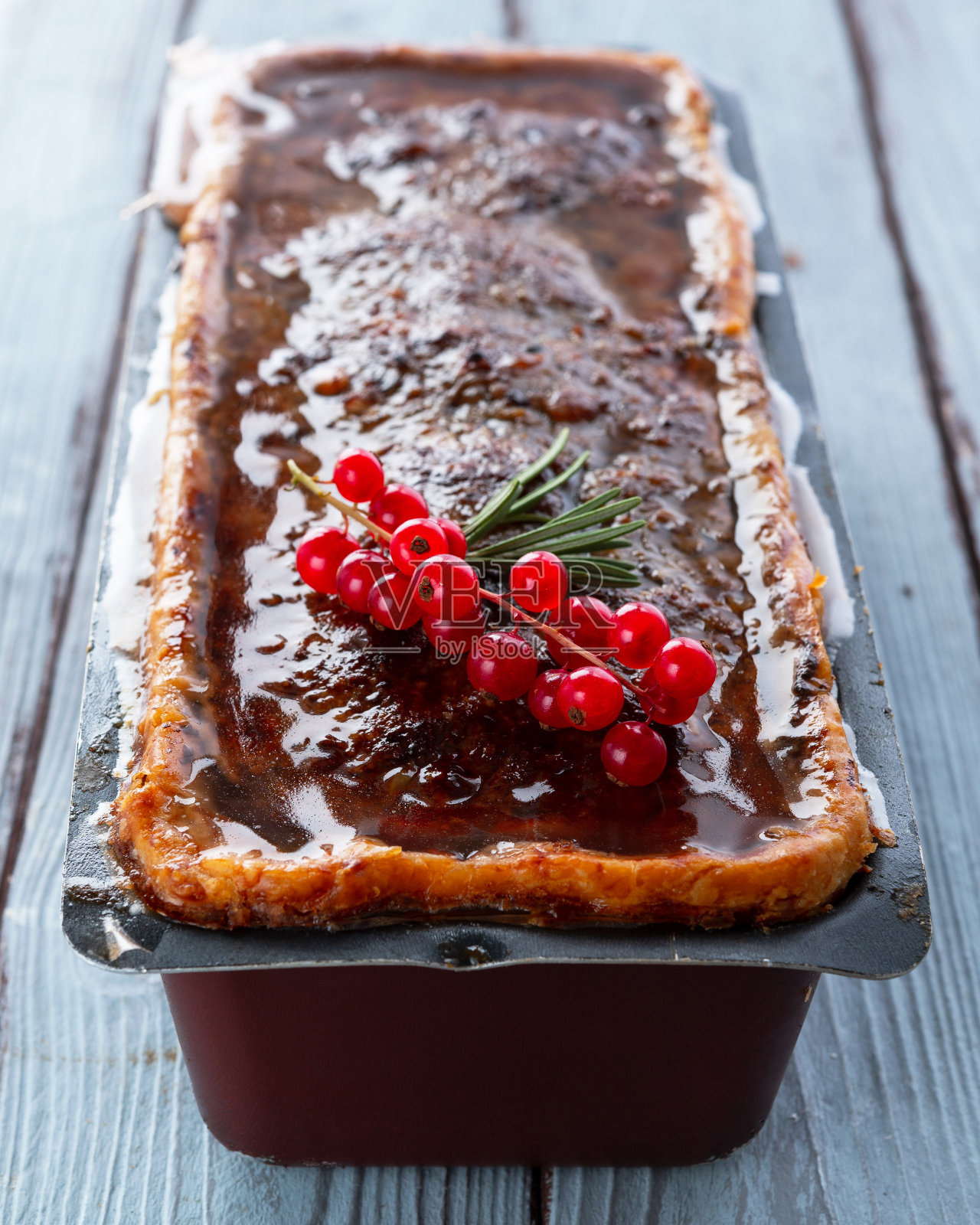 一个孤立的陶罐红醋栗和新鲜的迷迭香在青色的木板背景照片摄影图片