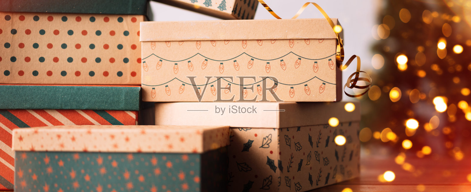 新年礼盒一个挨一个地放在圣诞树旁边照片摄影图片