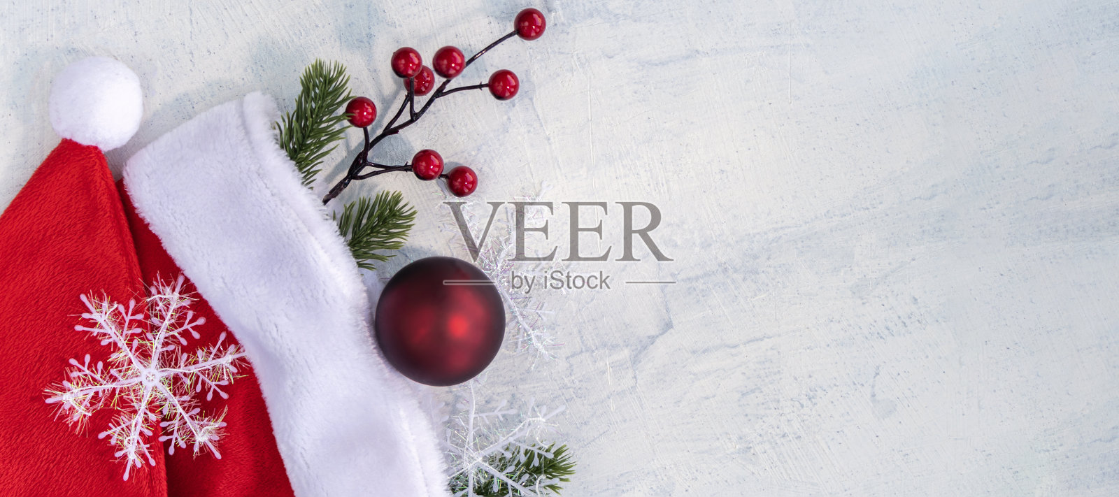 圣诞主题banner:红色圣诞球、圣诞帽和白色桌面照片摄影图片