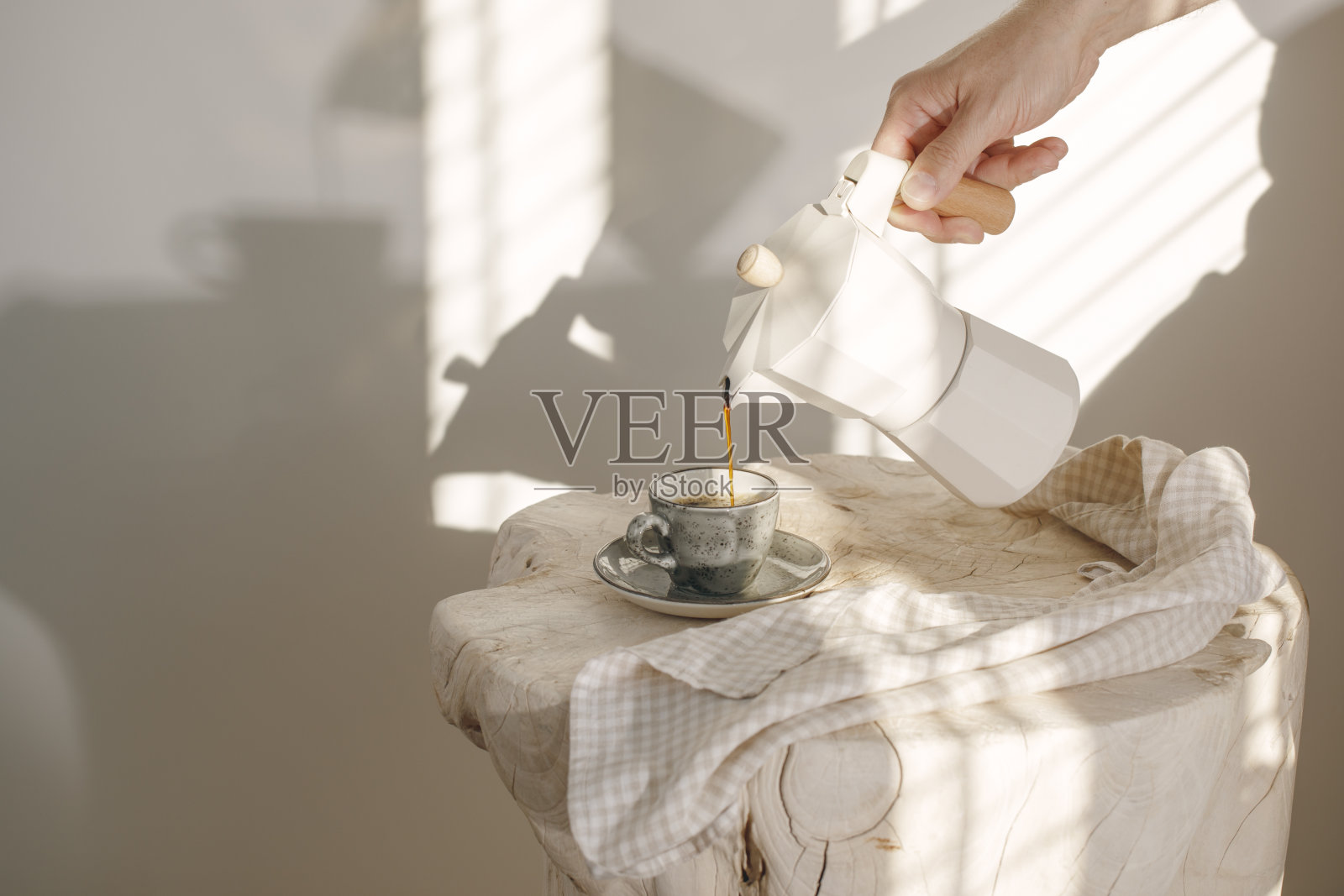 从意大利咖啡机与木制把手倒入灰色浓缩咖啡工艺杯在坚实的木桩装饰亚麻茶毛巾奶油色调与白色墙壁在阳光创造美丽的阴影照片摄影图片