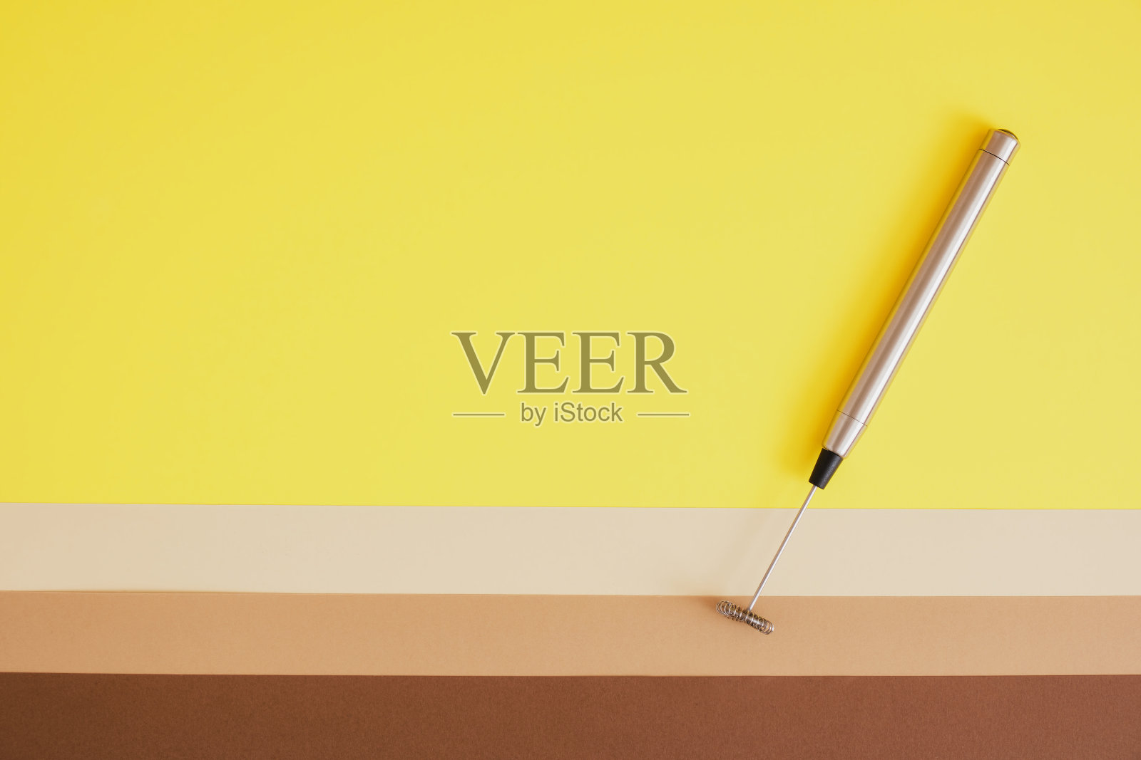 金属手持式牛奶蒸笼米色和棕色背景。手持泡沫或泡沫制造商关闭。照片摄影图片