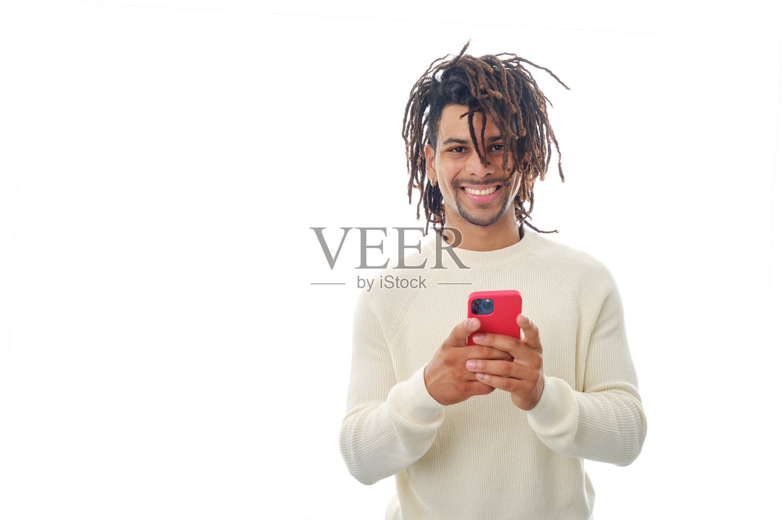 在一个孤立的背景下,一个拉丁男子拿着手机看着相机微笑。照片摄影图片