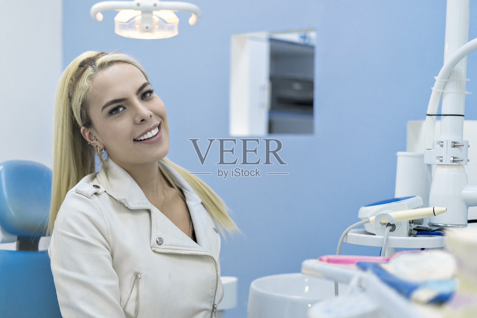 在牙科诊所微笑并看向镜头的患者照片摄影图片