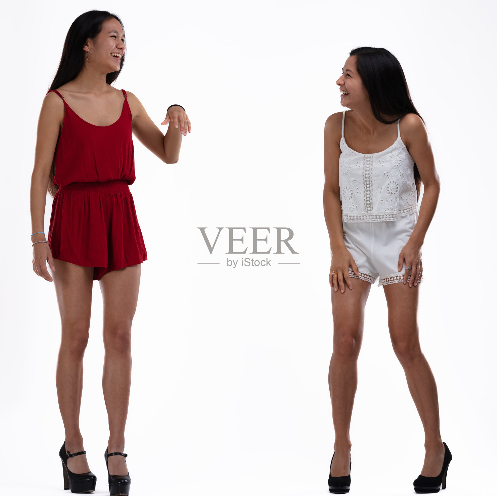 两个时髦的年轻女人站在一起笑着开玩笑照片摄影图片