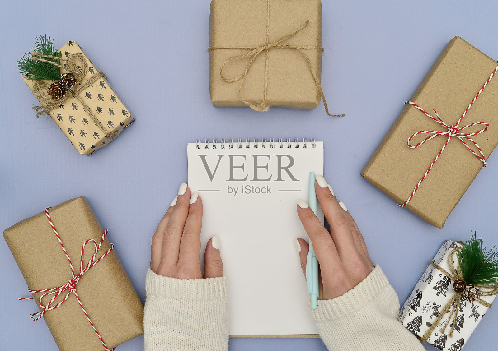 圣诞组成。礼物,女人的手和书写目标的白色笔记本。新年的背景。照片摄影图片