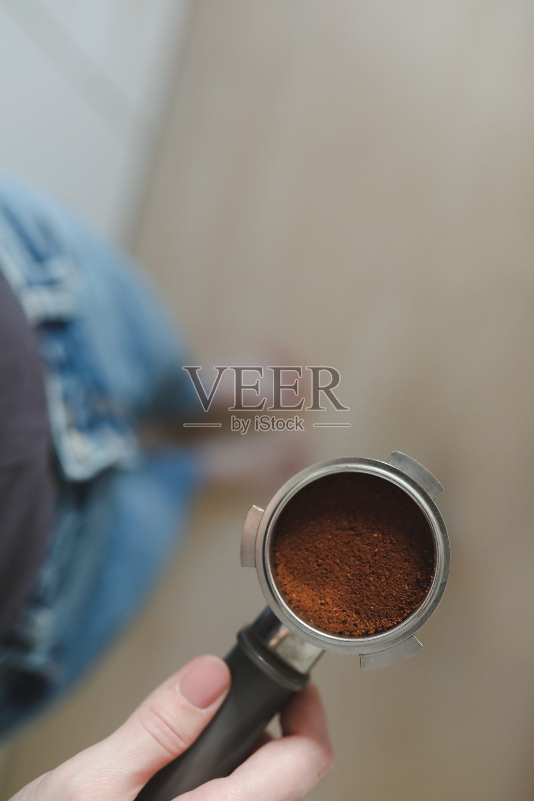 咖啡师煮咖啡,手里拿着咖啡机里的滤纸。特写镜头照片摄影图片