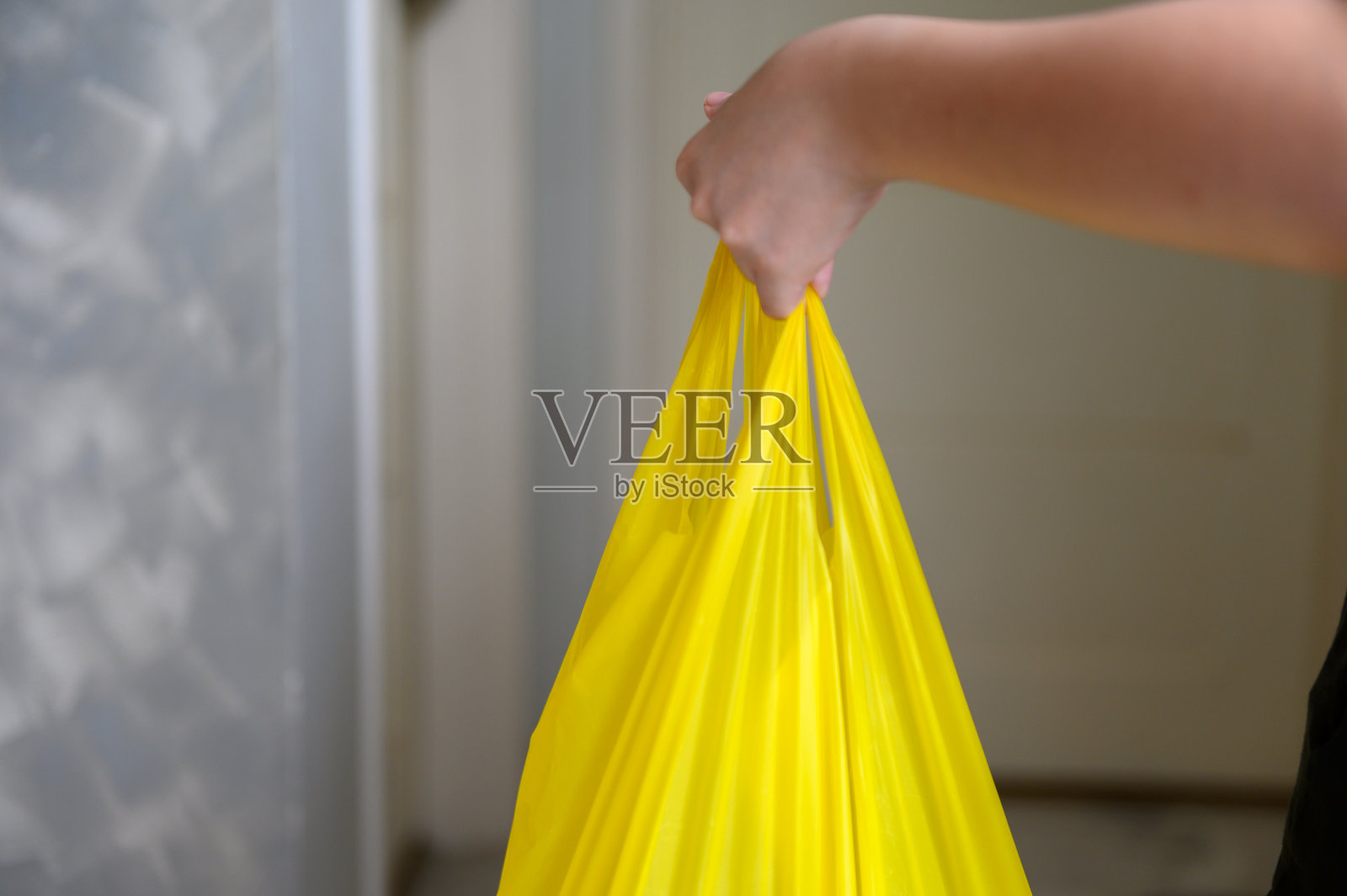 小男孩背着黄色的塑料袋照片摄影图片