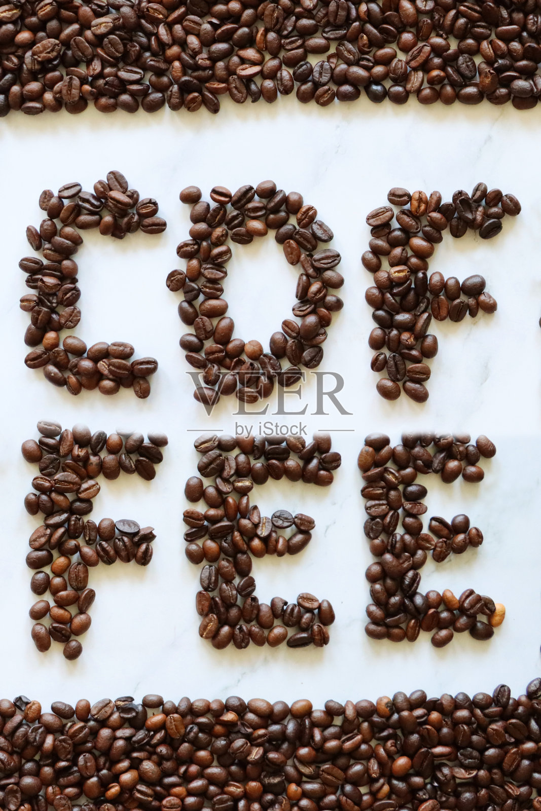 在大理石效果的背景上,用整颗咖啡豆写的单词“咖啡”被一框烘培的咖啡豆包围着,高视野照片摄影图片