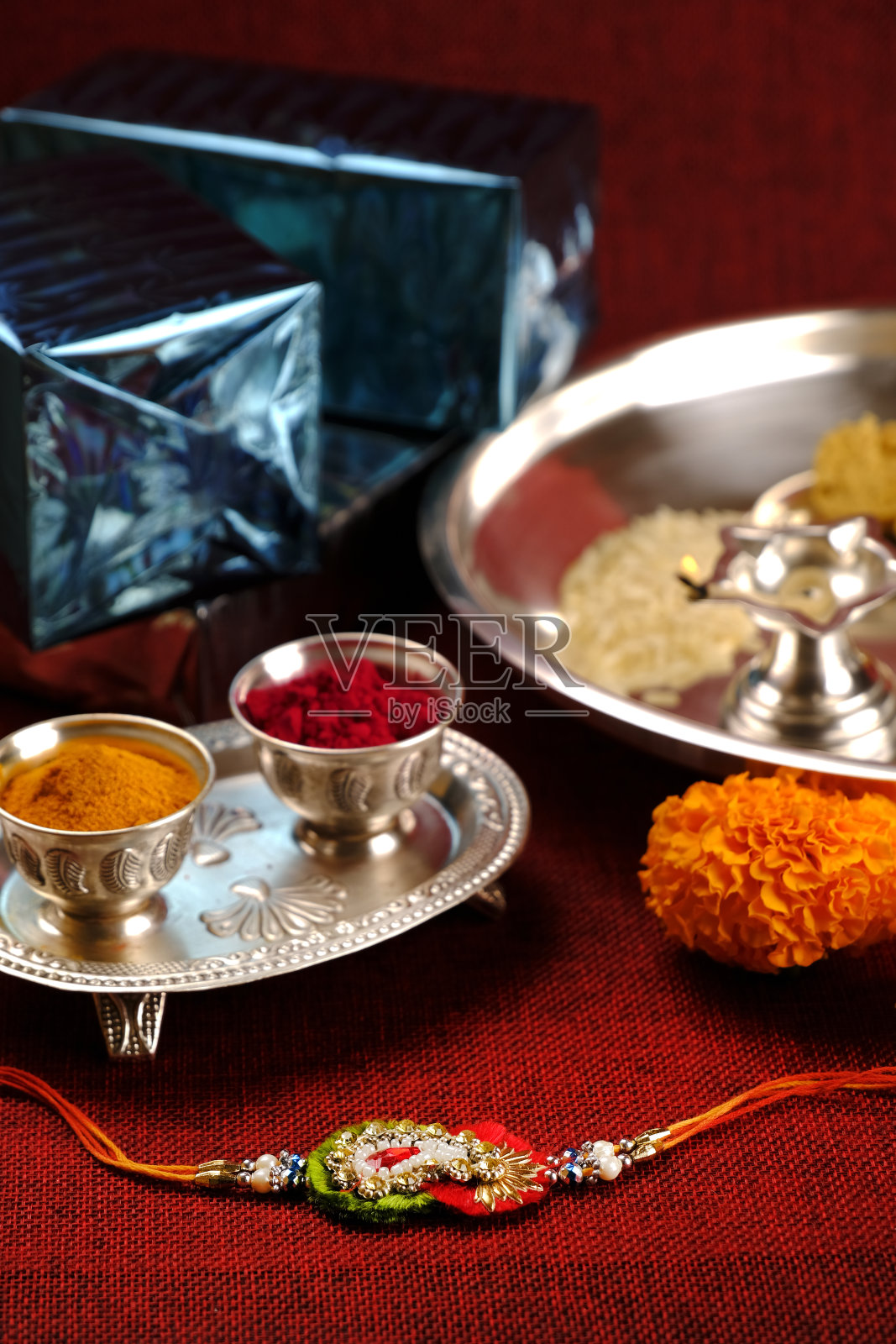 印度节日:Raksha bandhan, Raakhi与糖果礼物鲜花和diya, Raksha bandhan(保护和照顾的纽带),印度姐妹和兄弟的节日。照片摄影图片