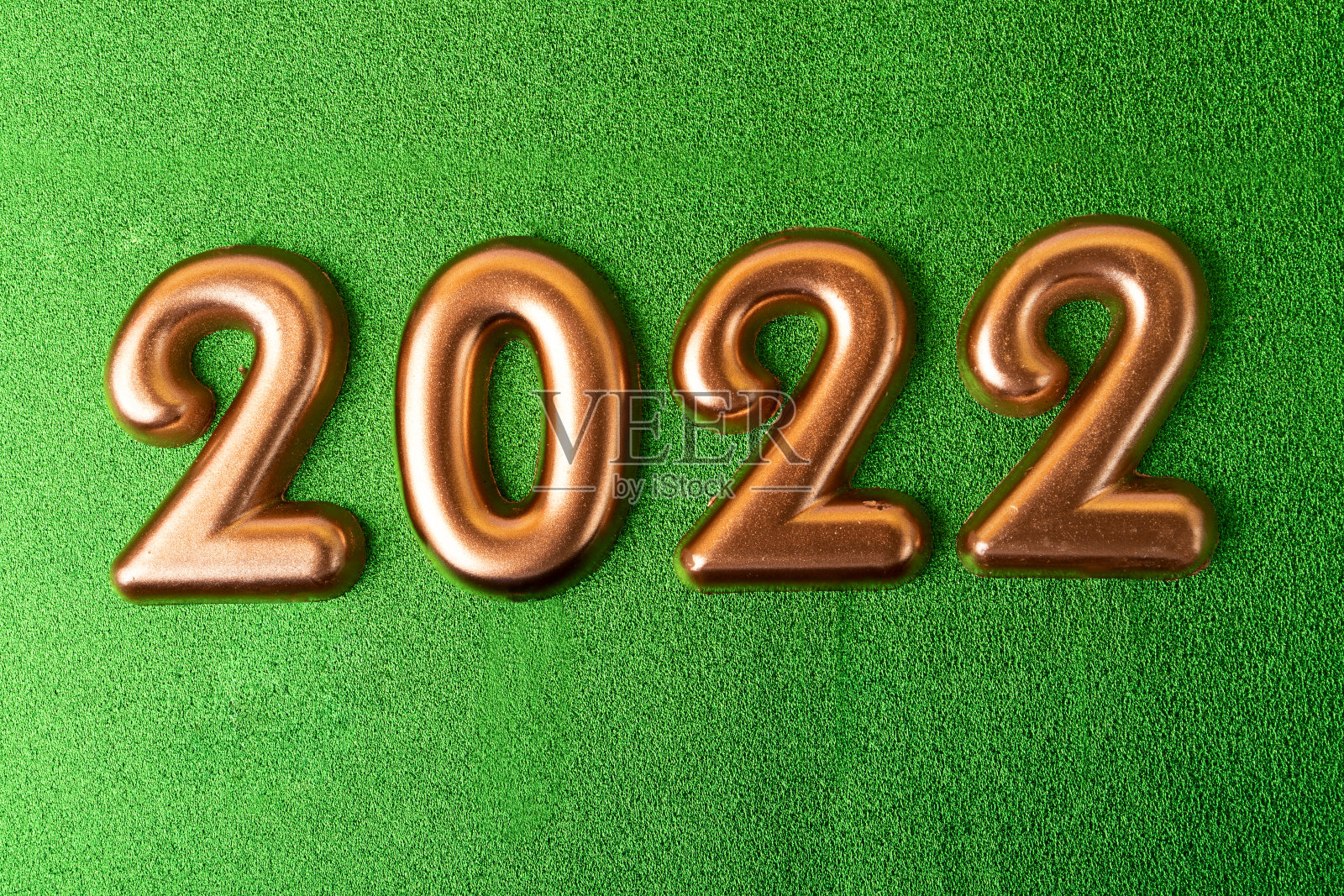 绿色背景上的玫瑰金编号为2022。照片摄影图片