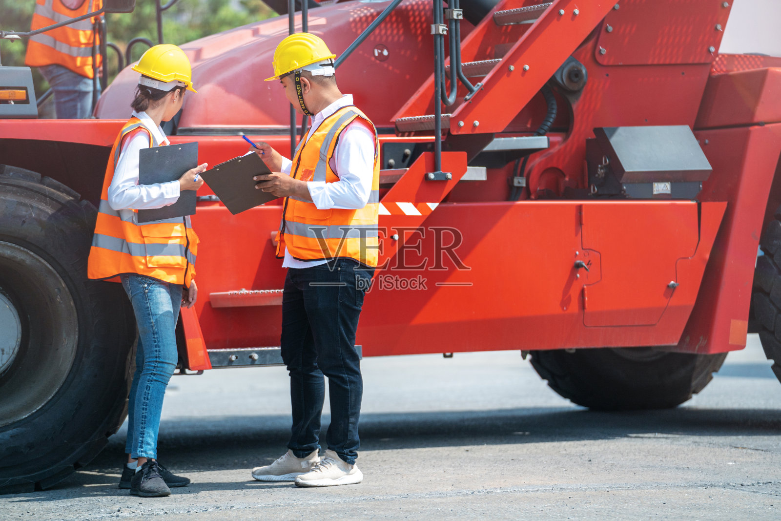 男人和女人的肖像工程师和工人在重型机械车辆前检查和会议。有信心和聪明的商业人士在航运运输行业工作。照片摄影图片