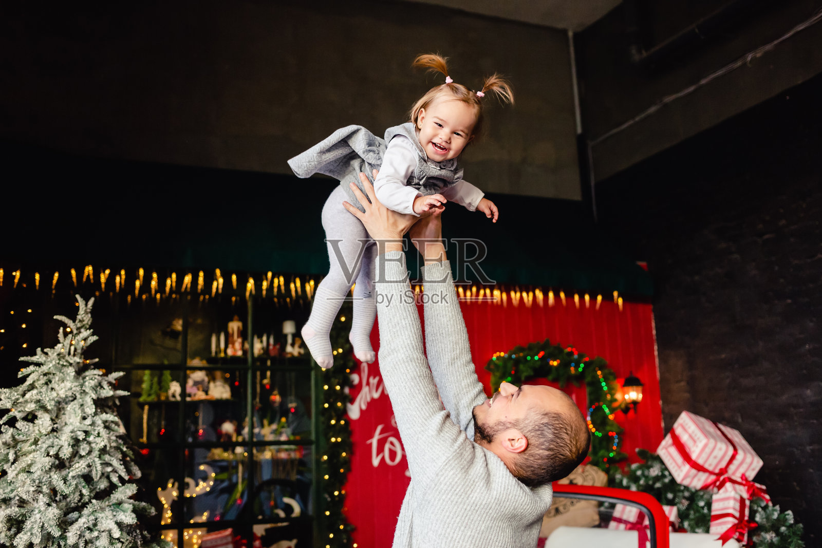 在圣诞节背景下,爸爸和孩子玩耍照片摄影图片