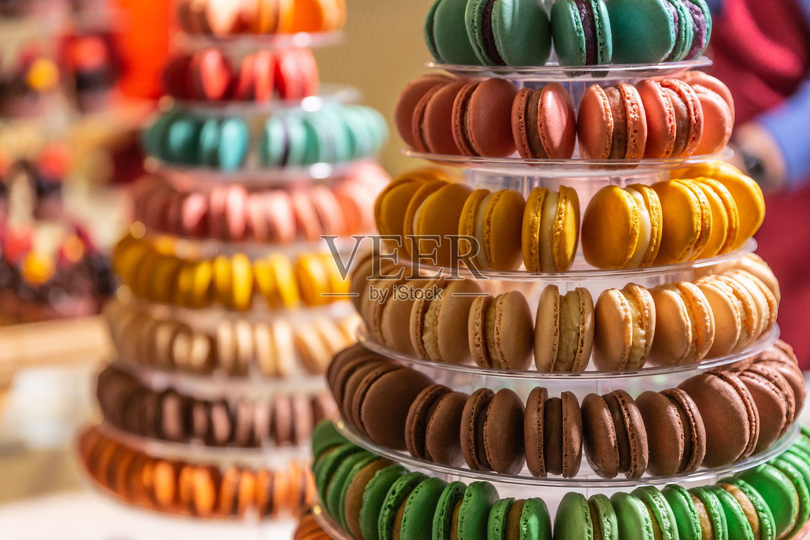 糕点店塔盘上的彩色杏仁饼干。照片摄影图片