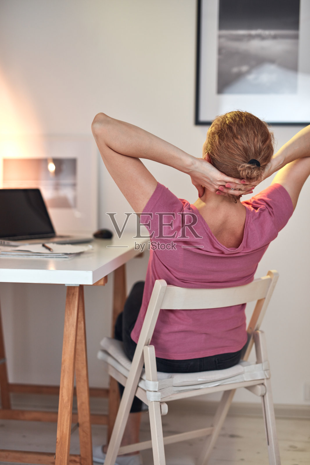 在家里用笔记本电脑工作,脖子疼的女人。照片摄影图片