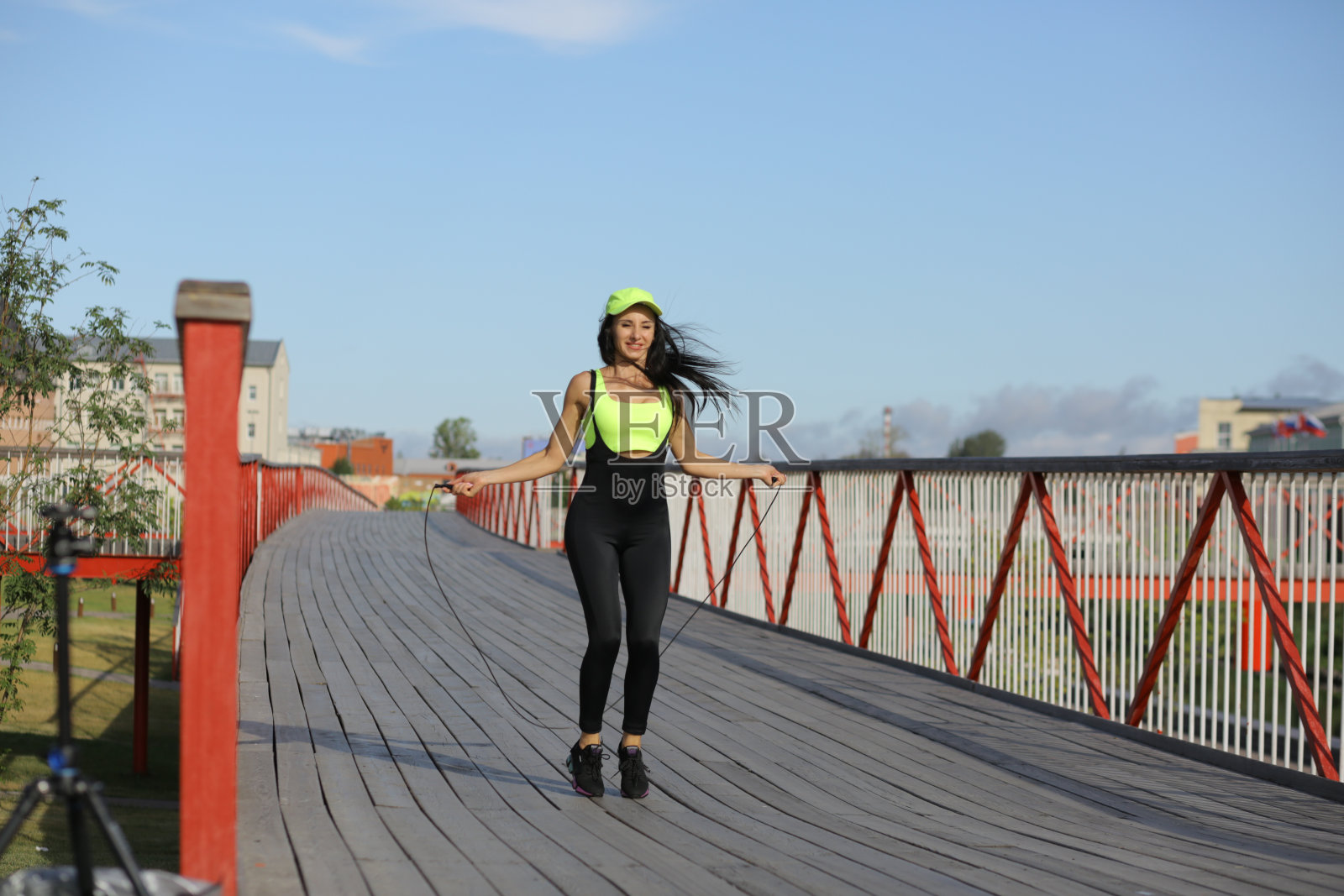 一个漂亮的女人在桥上跳绳照片摄影图片