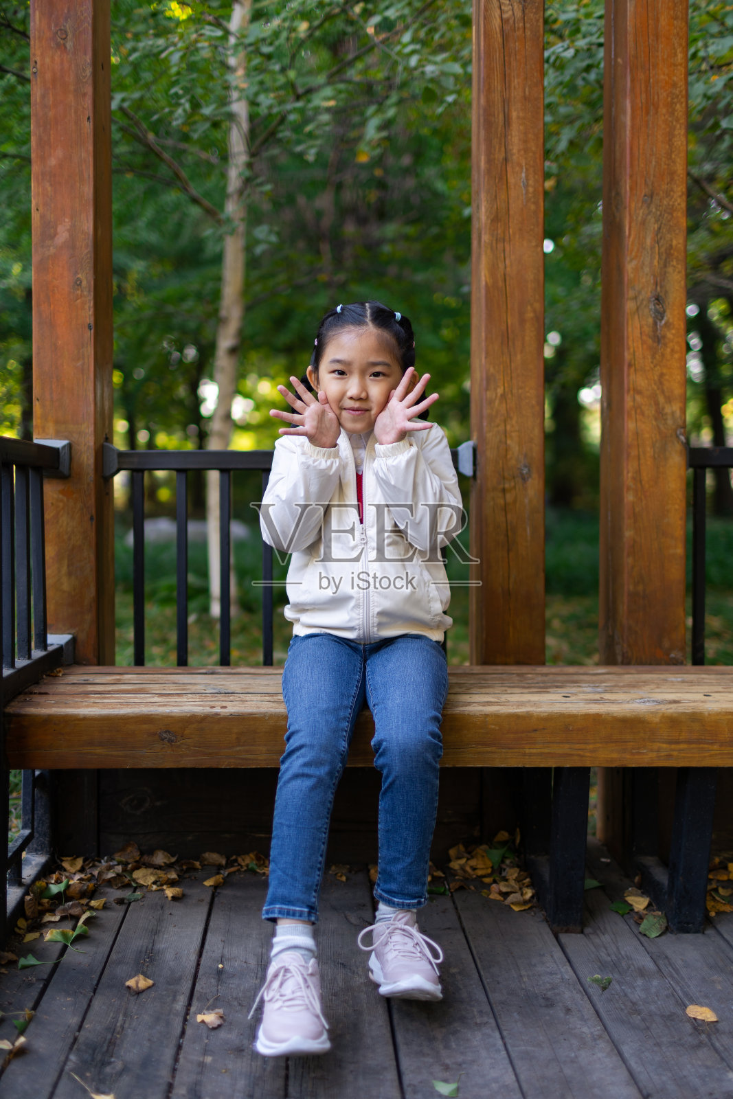 小女孩坐在公园里照片摄影图片