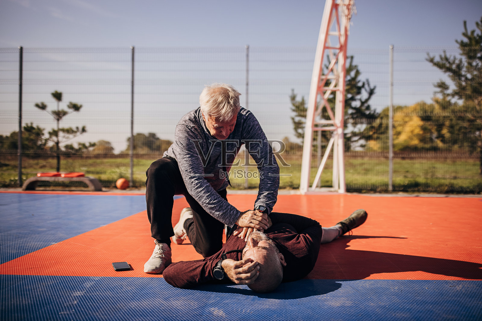 一名男子正在对一名昏迷的老人进行急救照片摄影图片