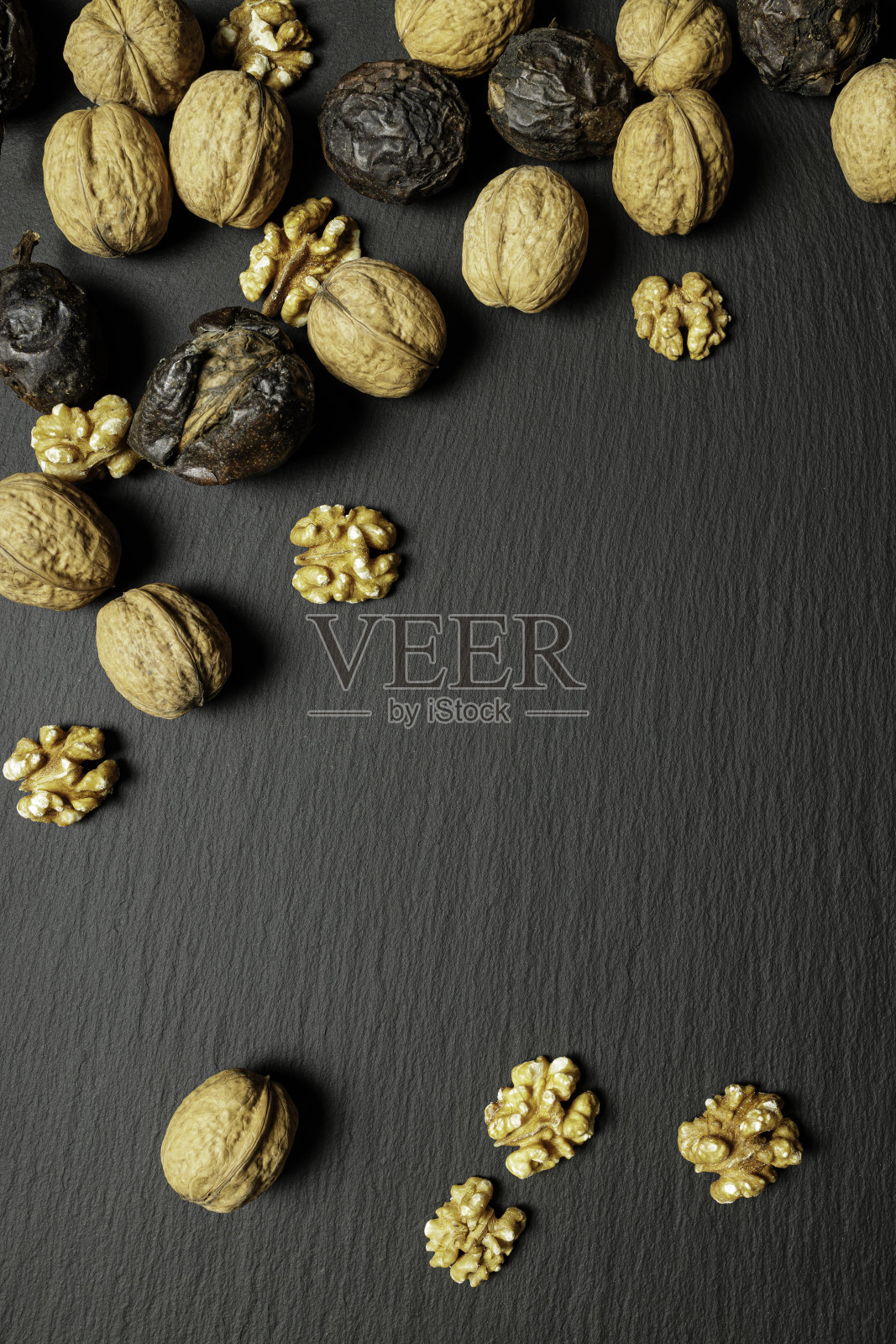 胡桃在黑色的石质背景上照片摄影图片