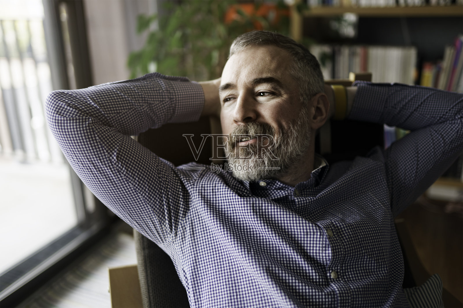 可爱的快乐的成熟男人在家里的公寓,灰色的胡子照片摄影图片