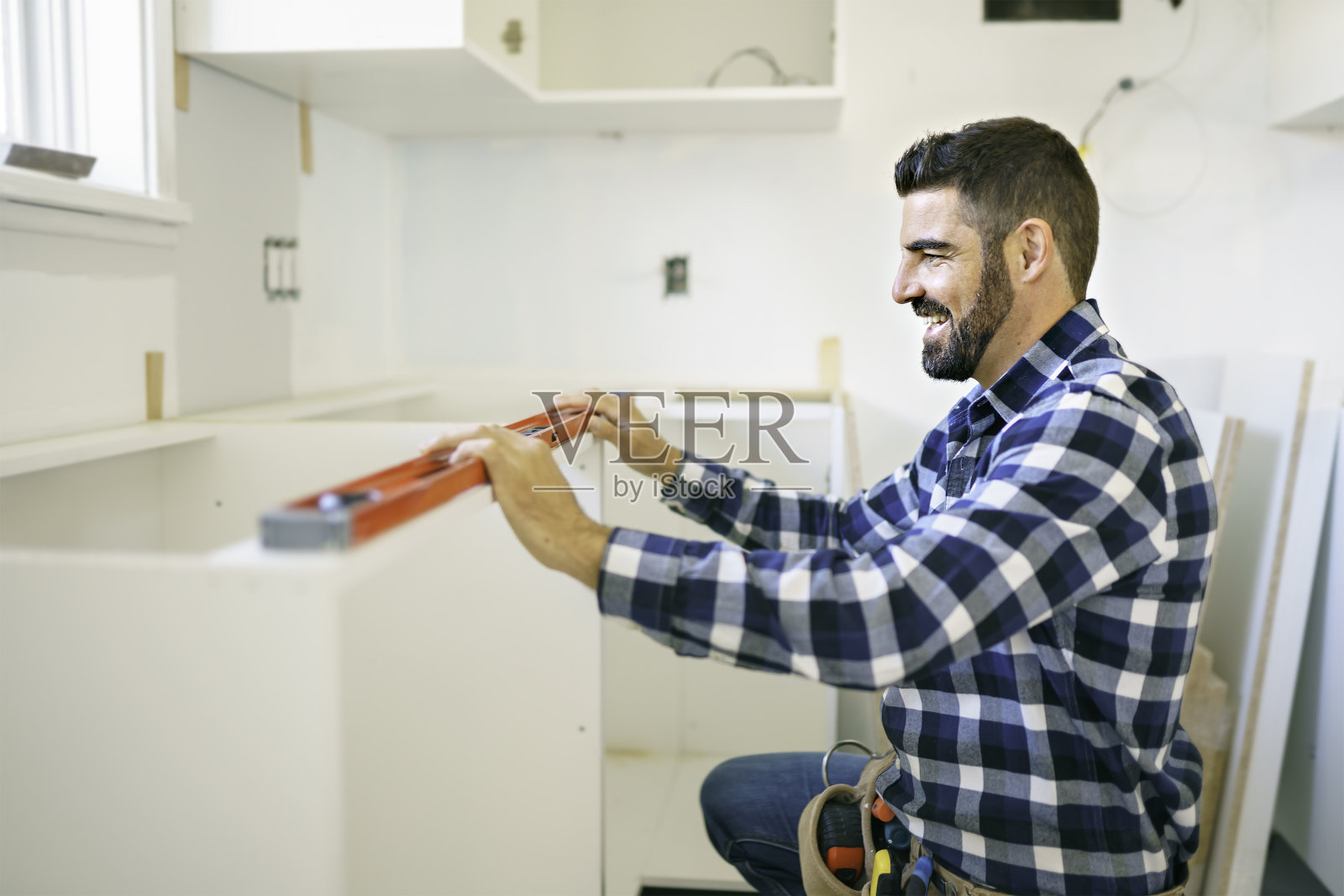 在厨房使用白色橱柜工作的专注年轻人照片摄影图片