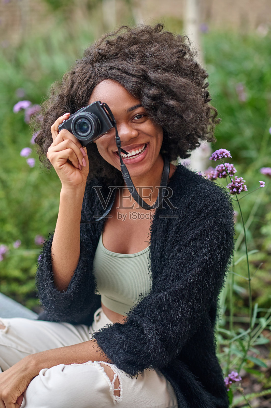 微笑的年轻女子,手里拿着相机照片摄影图片