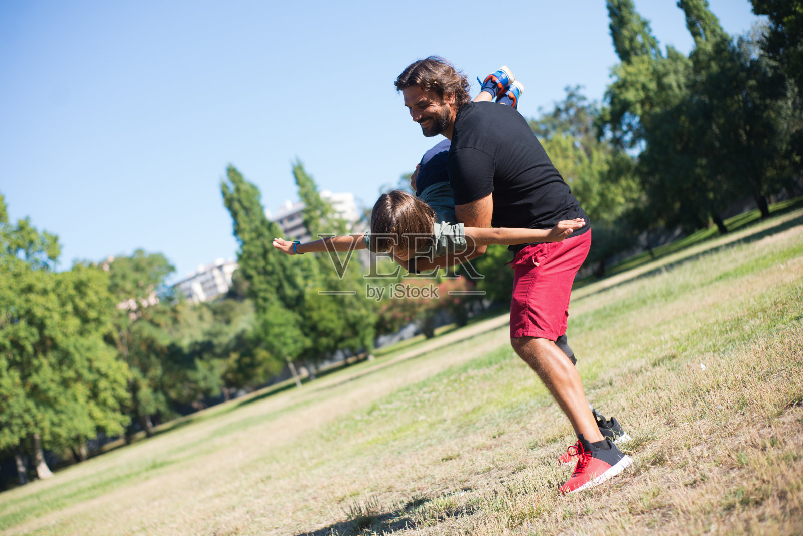 带着残疾的快乐父亲和儿子玩耍照片摄影图片