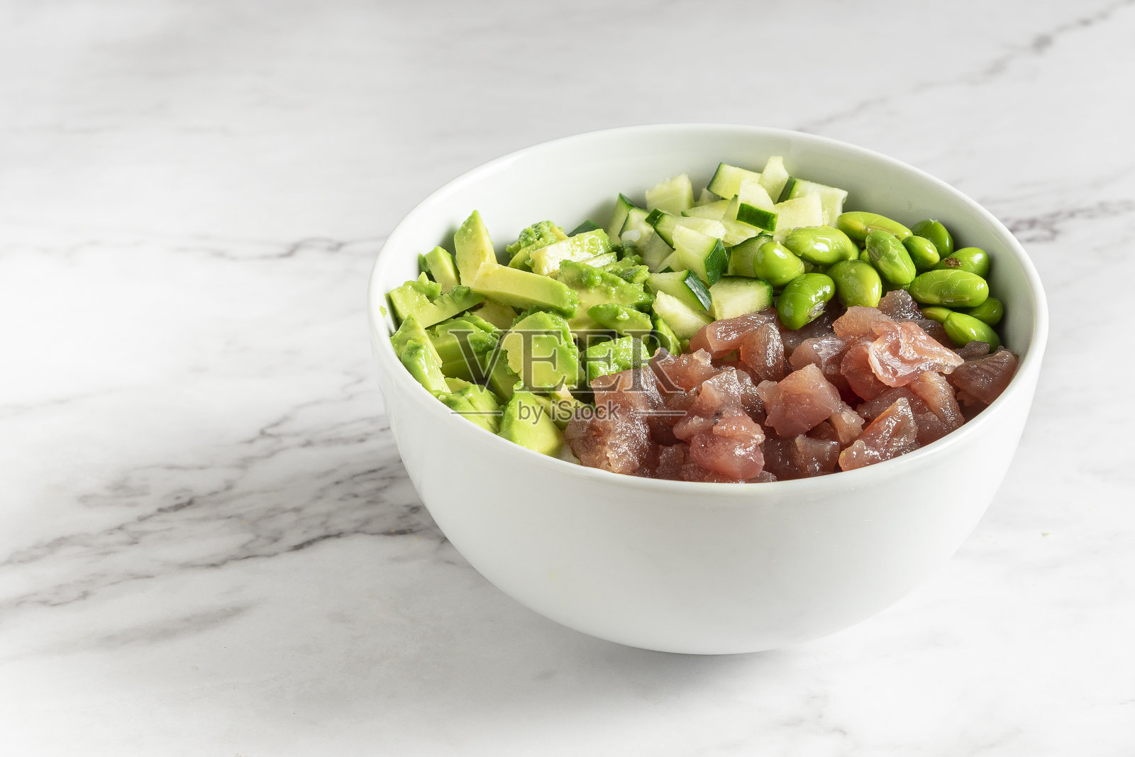 戳碗美味的三文鱼,青豆和鳄梨。健康食品的概念。照片摄影图片