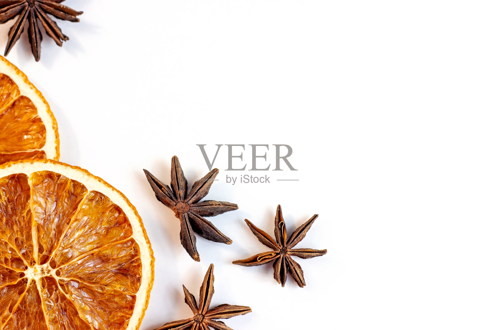 俯视图平面放置的圣诞香料,用于传统饮料:肉桂棒,八角星,干橙片作为圣诞季节的框架在白色背景与复制空间装饰照片摄影图片