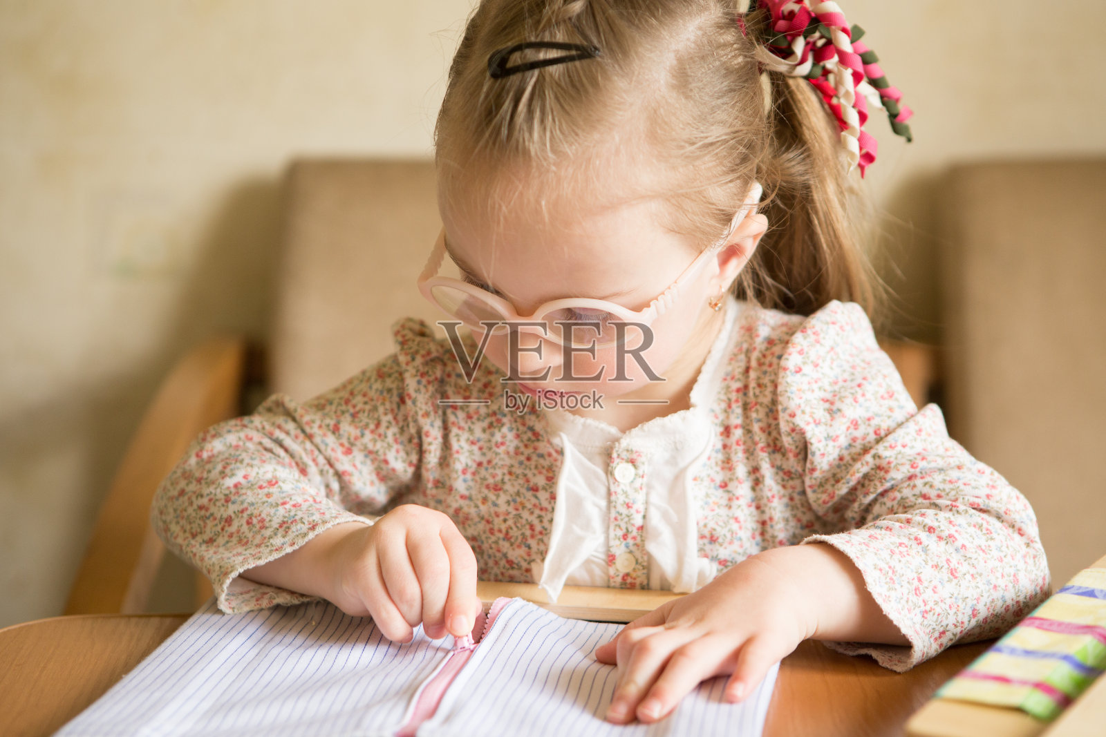 唐氏综合征女孩学习拉开衣服拉链照片摄影图片