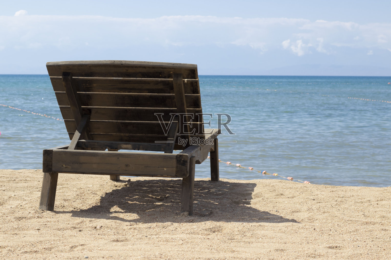 在一个蓝色湖泊附近的沙滩上休息。照片摄影图片