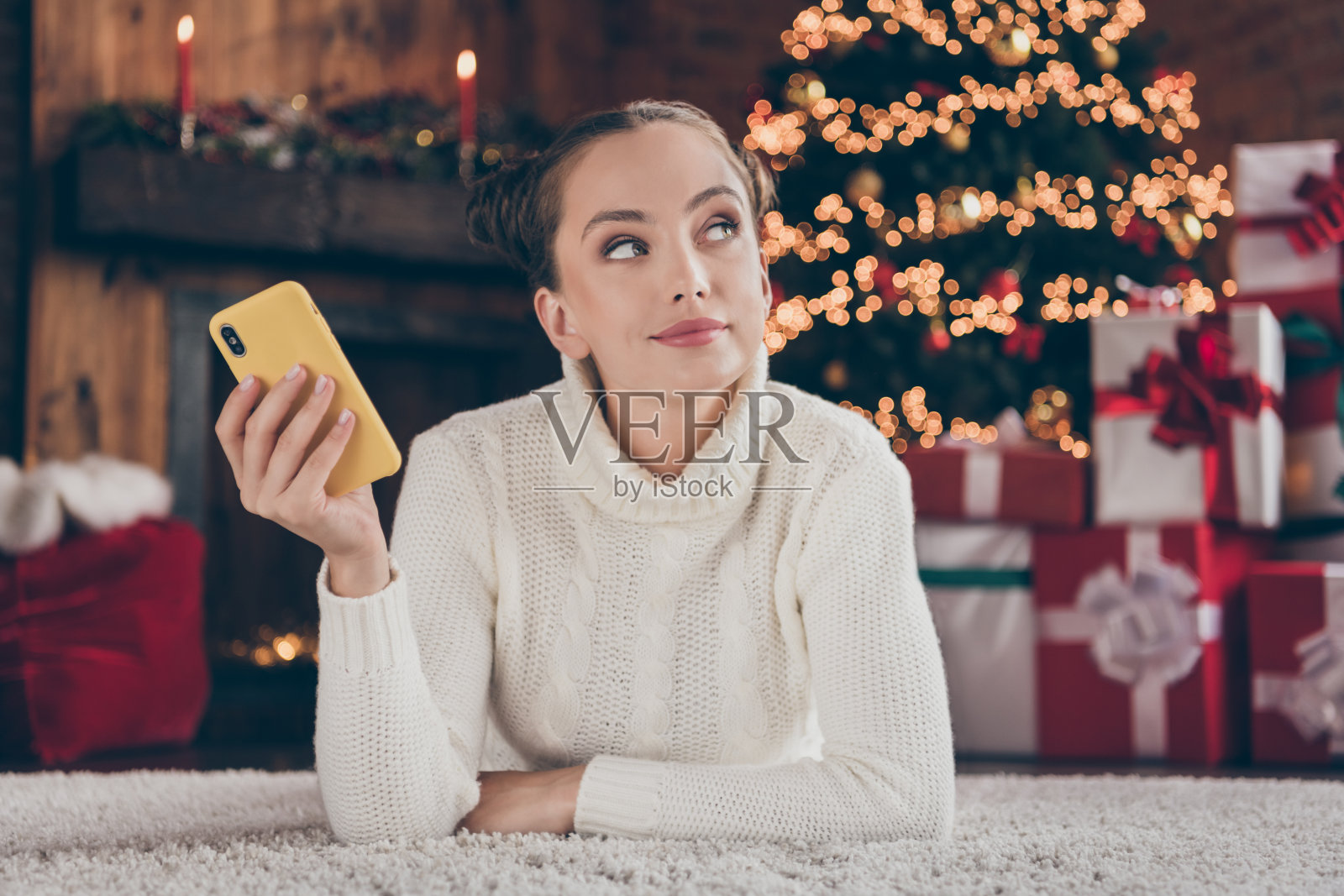 年轻可爱女孩的照片深思熟虑的计划举办智能手机装饰present寒假室内照片摄影图片
