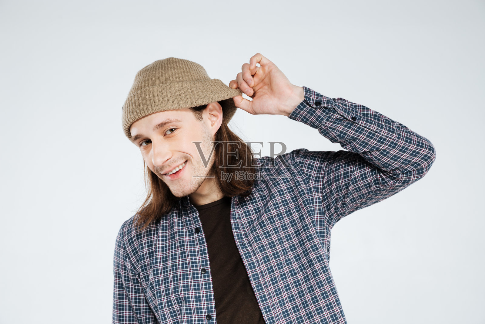 微笑的嬉皮士,拿着帽子,倾听着照片摄影图片